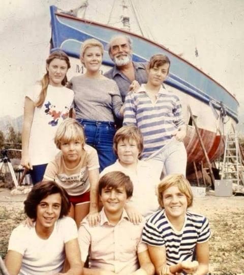 Foto de grupo del reparto de la serie Verano Azul delante de la barca de Chanquete